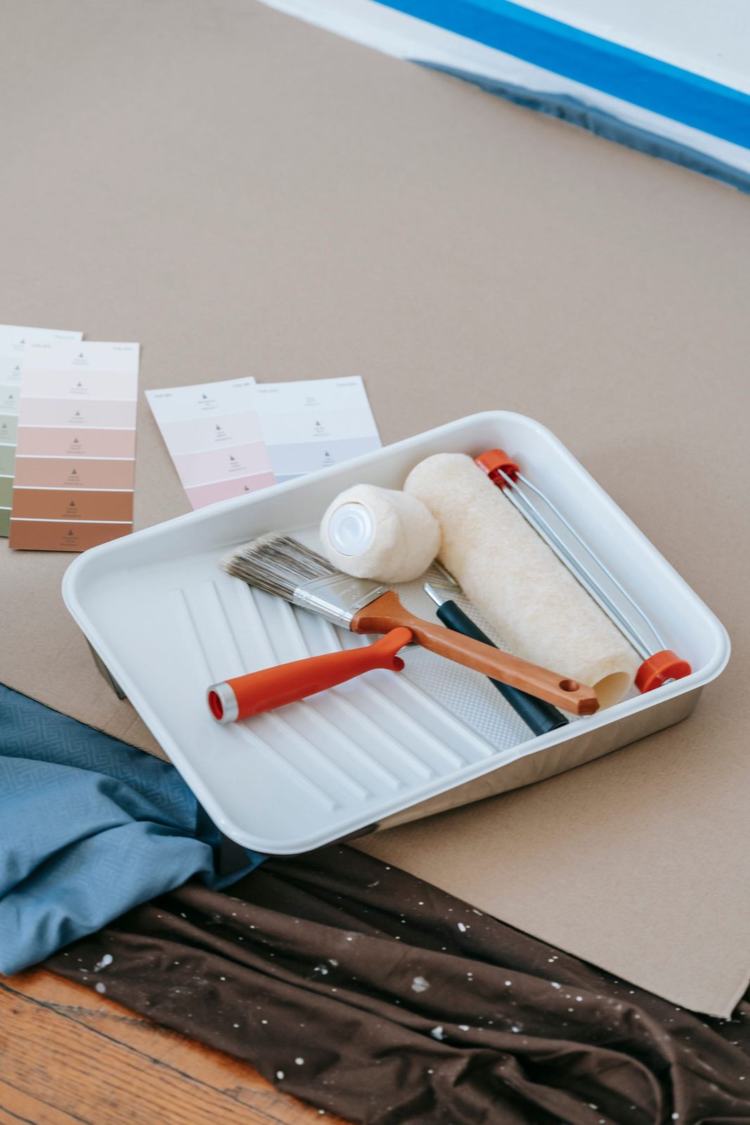 Paintbrush, roller, tray, and swatches for home renovation projects